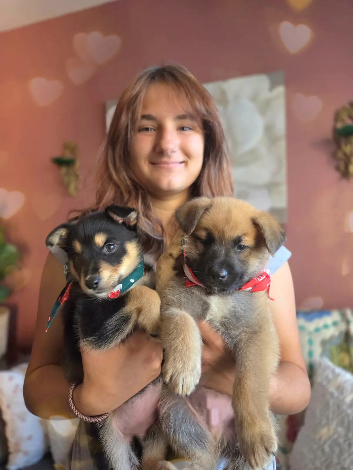 One of the kids holding two foster puppies.